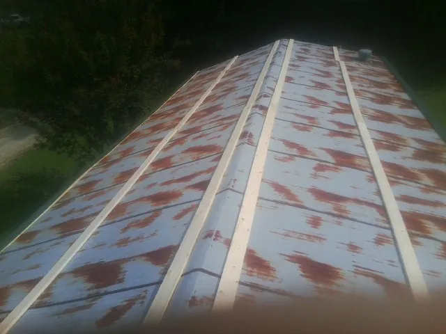 Rusted metal roof panels with new wood purlins before replacement — Storm Damage Roof Repair in Clemmons by Roofing Brothers