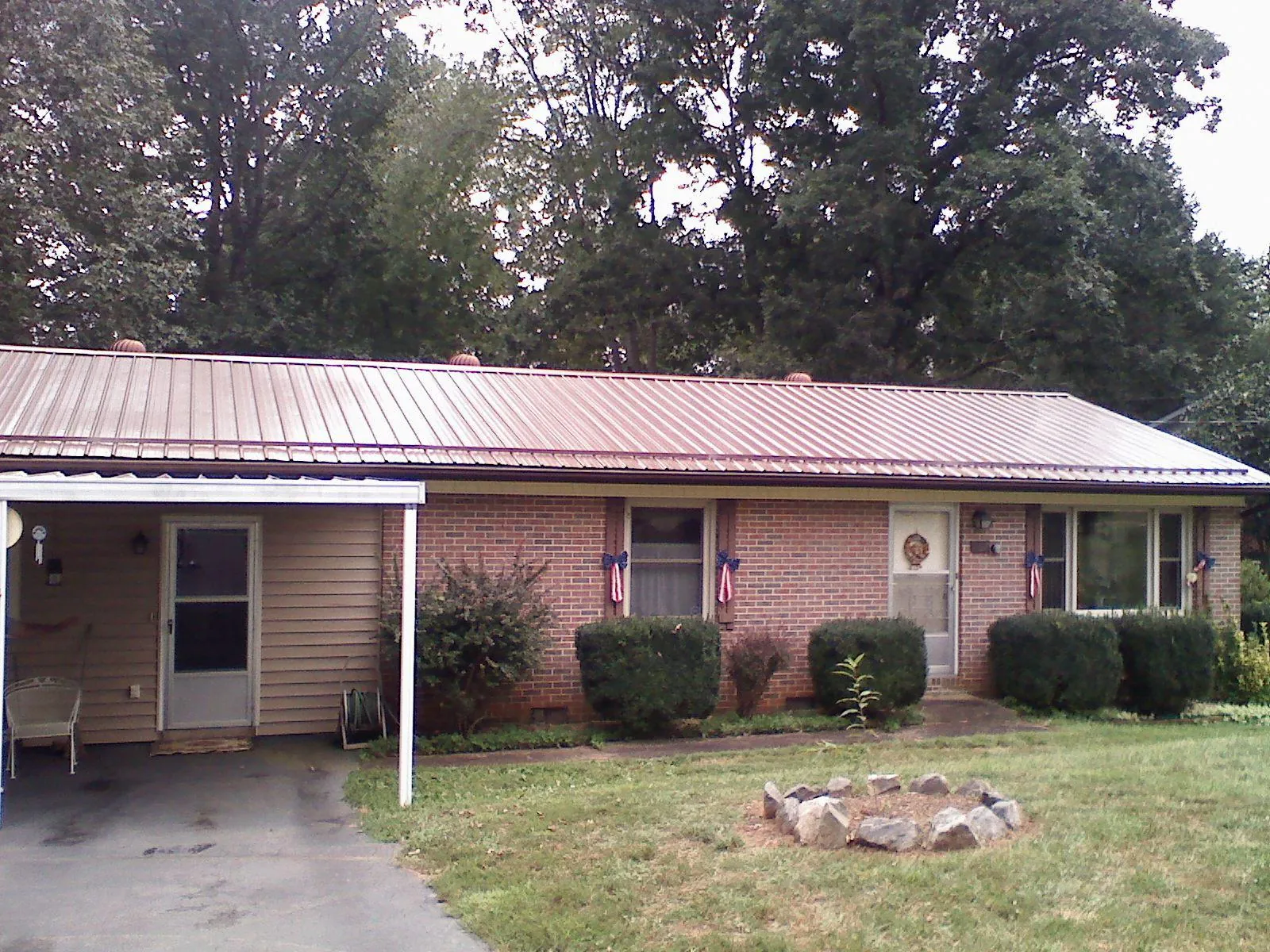 Bronze metal roof and carport on a brick ranch home — Roof Repair work by our crew in Clemmons
