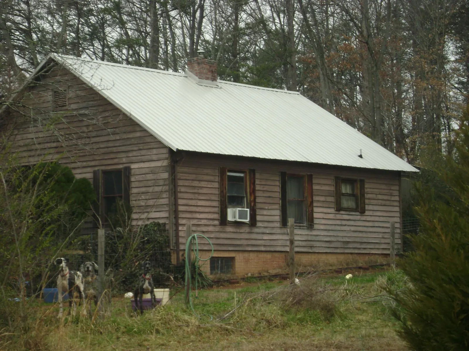 White metal roof on an old wood sided farmhouse, from a Metal Roof Installation job in Clemmons